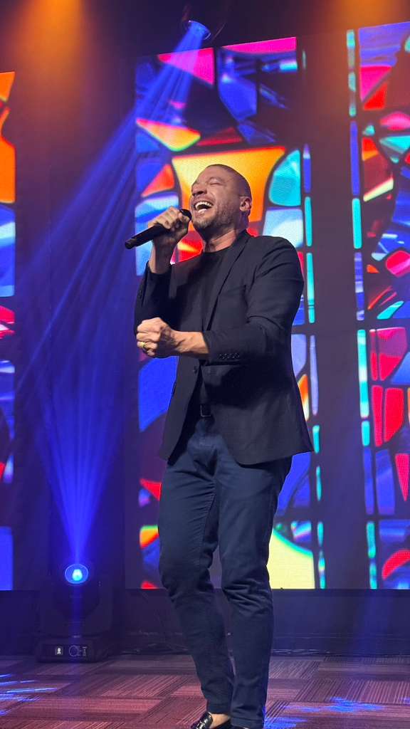 Milagres Tour — cantor no palco em noite de culto